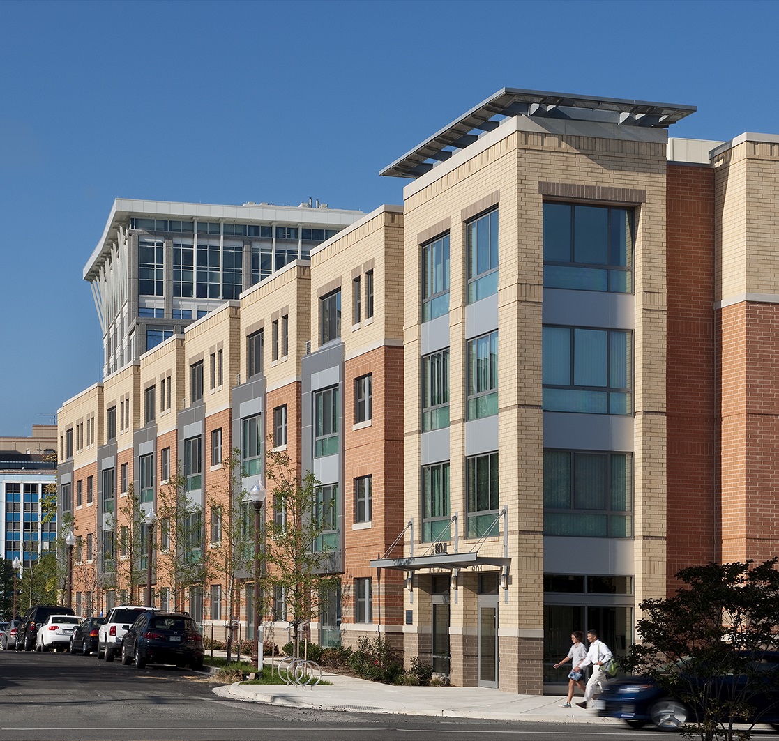exterior of multi level brown and cream building with large windows