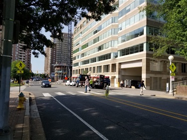 Two people cross N Quincy Street at 10th St N