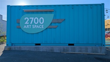 Blue shipping container with a sign reading ‘2700 ART SPACE.’