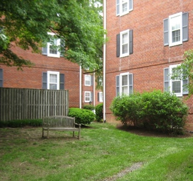 Photo of area between red brick apartment complexes before a tree was planted.