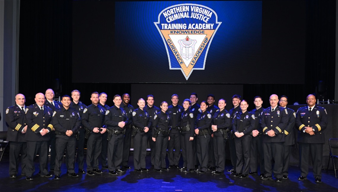 Group of police officers and Exec staff posing for a photo